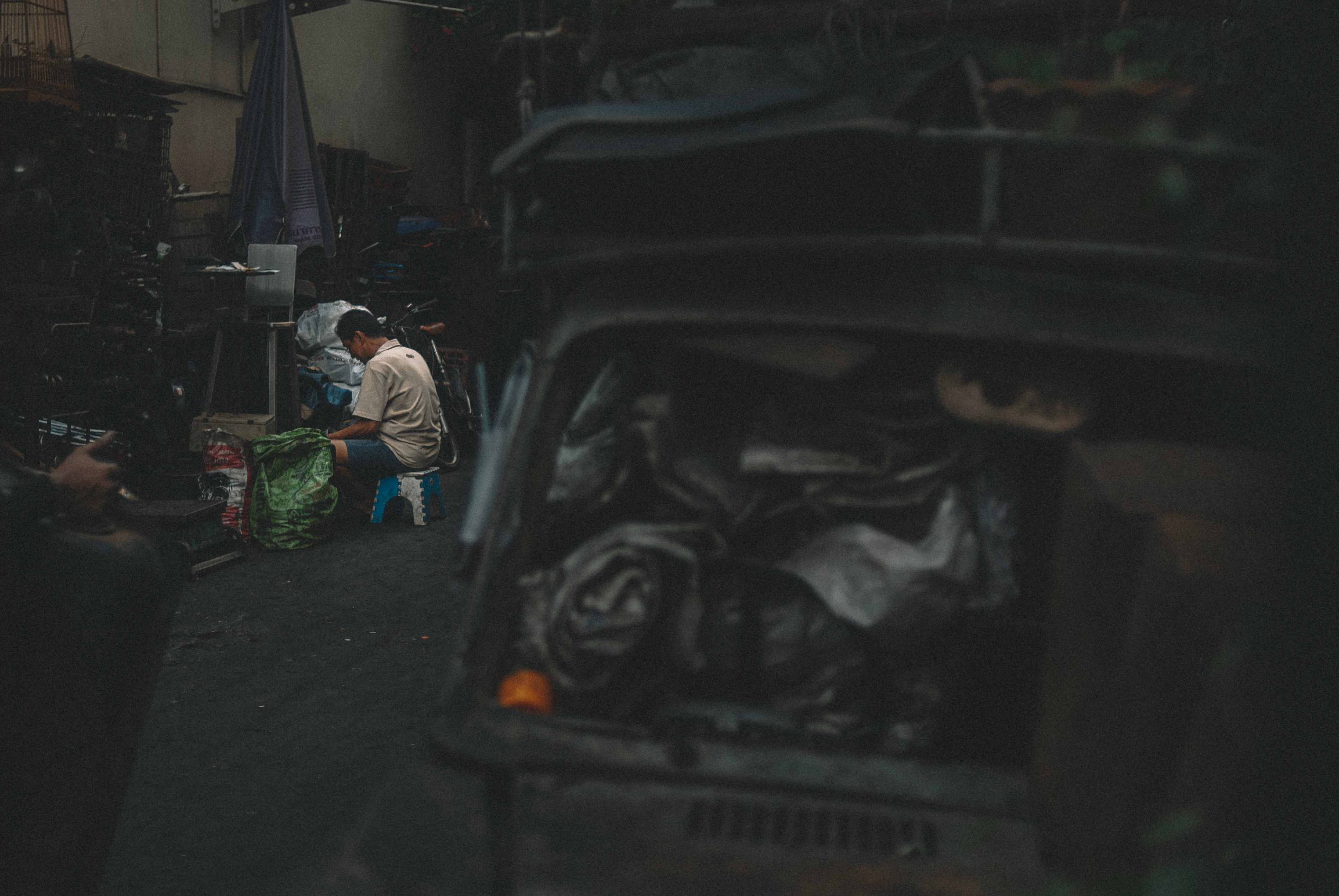 man in white long sleeve shirt and green pants sitting on black car